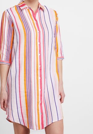 Donna che indossa un vestito al ginocchio con bottoni, a righe verticali rosa, arancione, viola e bianco, con maniche a tre quarti e colletto.
