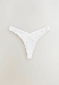 Perizoma bianco realizzato in tessuto testurizzato con linee verticali e un delicato bordo smerlato lungo i bordi.