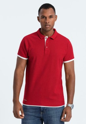 Polo rouge au design classique, avec un col blanc et des bordures blanches aux manches, fabriqué en tissu doux et texturé. Coupe décontractée, patte de boutonnage.