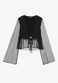 Black cropped blouse featuring sheer, polka dot mesh long sleeves, a layered ruffled hem, and a front tie closure for adjustment.