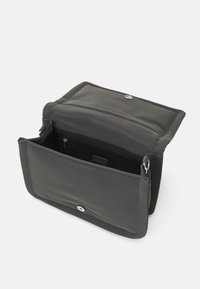Borsa nera in tessuto, forma rettangolare con chiusura a scatto magnetico. L'interno presenta una tasca con zip e una texture liscia.