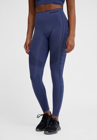 Blå atletiska leggings med ett strukturerat mönster och kontrastsöm. Tillverkade av ett stretchigt material, designade för aktiv användning.