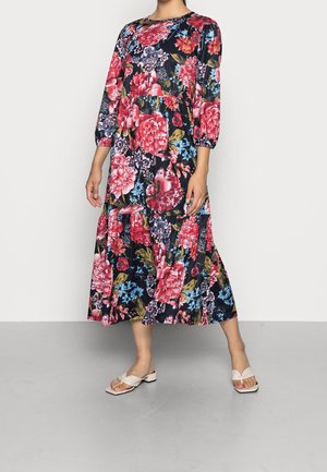 Lange bloemenjurk in marineblauw met rode en blauwe bloemen. Voorzien van driekwartmouwen en een rok met lagen. Glad stof met een ontspannen pasvorm.