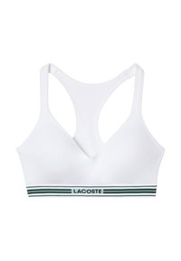 Top sportivo bianco con scollatura a V, caratterizzato da un bordo striato verde nella parte inferiore con il testo "LACOSTE". Tessuto liscio e stile a corsetto.