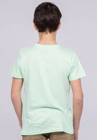 T-shirt en coton vert menthe à manches courtes et col rond, présentant une texture simple et lisse et une coupe droite à l'ourlet.