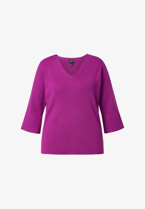 Lilla striktrøje med V-hals, trekvartlange ribstrikkede ærmer og en afslappet pasform. Tekstureret mønster på ærmerne med sidestykke.