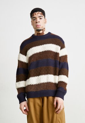 Jersey de punto con amplias rayas horizontales en marrón, azul marino y crema, con un acabado texturizado y fuzzy, y mangas y dobladillo acanalados.