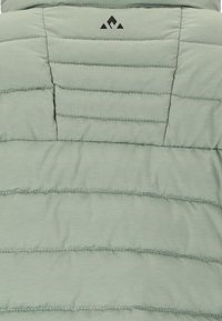 Hellgrüner gesteppter Stoff mit horizontalen Nähten und einem kleinen schwarzen geometrischen Logo nahe der oberen Mitte.