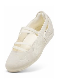 Ballerine en daim ivoire avec des bretelles élastiques croisées, intérieur rembourré et logo Puma sur le bout.
