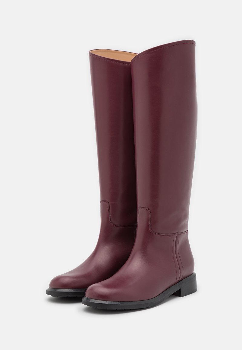 Burgunderfarbene Leder-Stiefel bis zum Knie mit glatter Oberfläche, runder Zehenpartie, niedrigem Blockabsatz und minimaler Nahtdetail an den Seiten.