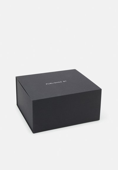Black rectangular box made of rigid material with a matte finish, featuring white text "PUBLISHED BY" on the top surface.