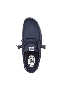 Marine canvas instap schoenen met witte zool, met een vetersluiting en een gevoerde binnenkant met blauwe geometrische patronen.