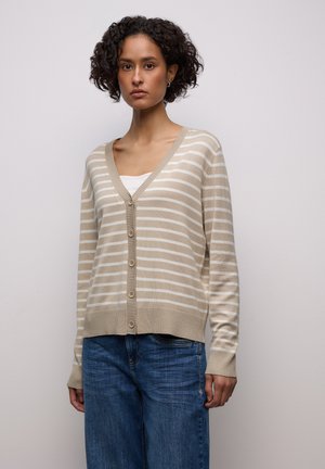 Beiger und weiß gestreifter Cardigan aus weichem Strickstoff mit V-Ausschnitt, Knopfverschluss und gerippten Bündchen, kombiniert mit blauen Jeans aus Denim.