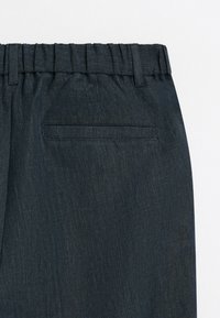 Dark tailored pants with an elastic waistband, belt loops, and a single back welt pocket, shown against a plain light background.