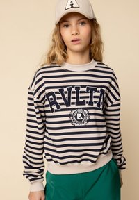 Gestreepte sweatshirt in marineblauw en roomkleur, met opvallende letters en een logo binnen een cirkelontwerp. Zacht materiaal met geribde manchetten.