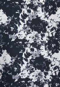 Marinblå och vit abstrakt blommönster på texturerad tyg, som har oregelbundna former och kontrasterande färger med en subtil designdjup.