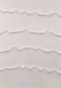 Weißer Strickstoff mit drei horizontal gestickten, wellenförmigen Linien, die der glatten Oberfläche Textur und Detail verleihen.