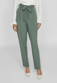 Green tapered trousers with a bow tie belt, made of smooth fabric. Features a high waist and a relaxed fit, suitable for casual or formal wear.