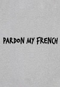 T-shirt in tessuto grigio con testo nero audace che recita "SCUSA IL MIO FRANCESE". Il testo è ben in evidenza in un carattere giocoso e irregolare.