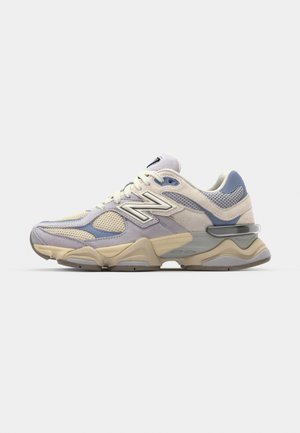 Scarpa da corsa leggera in beige, azzurro chiaro e grigio. Parte superiore in rete e camoscio, colletto imbottito e suola spessa con accentuazioni prominenti.
