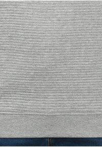 Gray textured sweatshirt featuring a ribbed design and a solid hem, paired with dark denim jeans below.