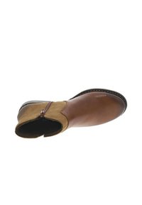 Stivale alla caviglia in pelle marrone con tomaia in suede beige, zip laterale, punta arrotondata e cuciture a contrasto lungo la suola.