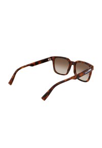 Sunglasses dengan corak tempurung penyu, berbentuk segi empat, dengan lensa gradasi, dan detail engsel logam. Dilengkapi dengan reka bentuk bingkai bercorak.