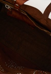 Borsa tote in tessuto marrone con tracolla in pelle. Interno strutturato con dettagli di cuciture e colore marrone uniforme. Design con apertura superiore.