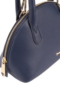 Marine leren handtas met een ronde vorm, gouden metalen rits en hardware, textuur oppervlak en dubbele handvatten. Bevat een merklogo accent.