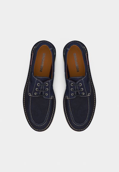 Chaussures décontractées bleu marine en daim avec lacets, coutures blanches et semelles intérieures marron, marque DSQUARED2, vues de dessus sur fond blanc.