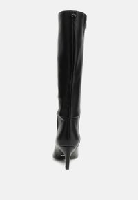 Stivali neri in pelle alti fino al ginocchio con punta appuntita, tacco a stiletto, texture liscia e accento con logo G sul retro.