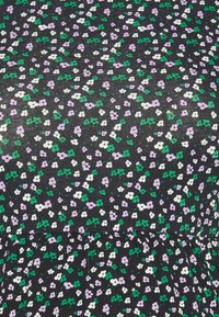 Tecido preto com um pequeno padrão floral apresentando flores roxas, brancas e verdes. A textura é estriada e há um detalhe franzido na parte inferior.