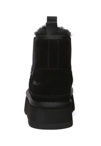 Black suede ankle boots with a soft fur trim, featuring a chunky black sole and a tab for easy wear. Smooth texture, minimal design accents.