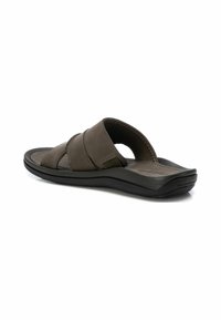 Sandalias de piel marrón con tres correas entrecruzadas, plantilla acolchada y suela de goma negra. Textura suave y diseño minimalista.