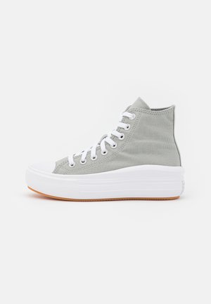 Szary wysokowytrzymały tenisówka z materiału płóciennego z białymi sznurowadłami, grubą białą gumową podeszwą oraz jasnobrązową podeszwą zewnętrzną, widoczna z boku na białym tle.