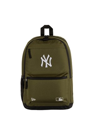 Mochila verde oliva con cremalleras negras, logo blanco de NY en el frente y pequeños logos de MLB y New Era en la parte inferior.