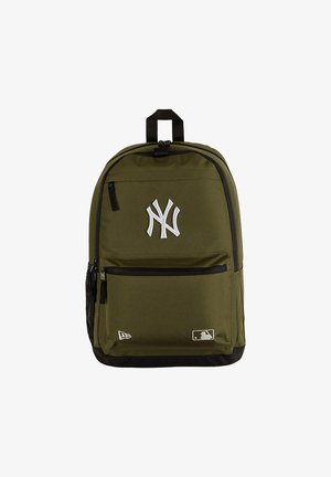 Mochila verde oliva con cremalleras negras, logo blanco de NY en el frente y pequeños logos de MLB y New Era en la parte inferior.