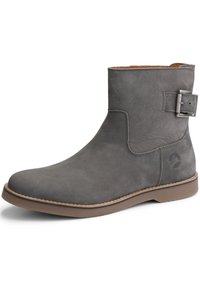 Šedá kožená kotníková bota s mírným špičkovým krytem, plochou texturou materiálu, bočním detaily přezky a kontrastní hnědou gumovou podrážkou.