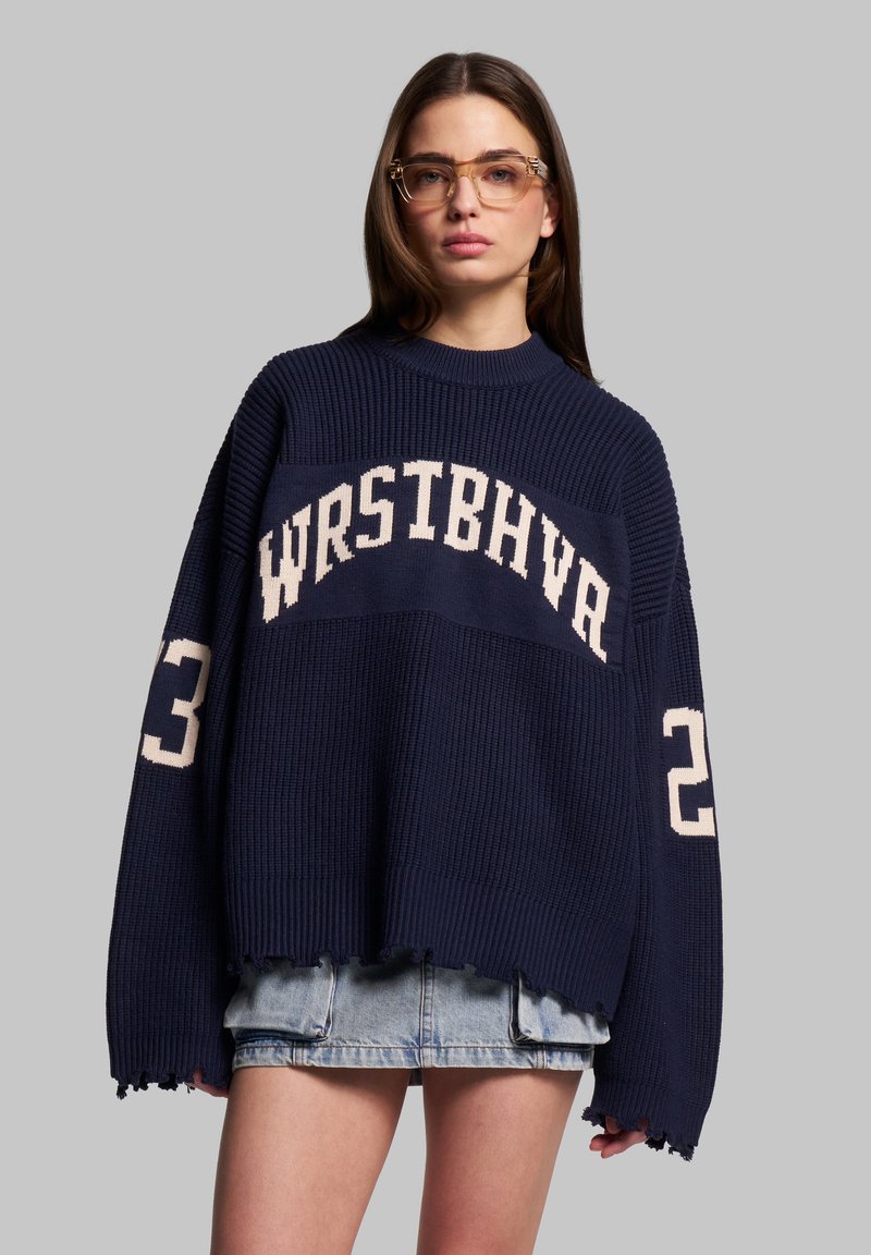 Maglione navy oversize con texture a coste, con scritta in maglia bianca "WRSTBHVA" e numero "23" sulle maniche. Dettaglio orlo sfrangiato.