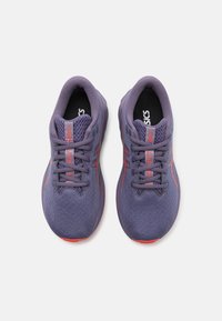 Violet sportiniai bateliai su tekstūruotu tinkleliu viršuje, kontrastingos raudonos detalės, su raišteliu užsegimu ir guminiais padais. Sukurti komfortui ir paramai.