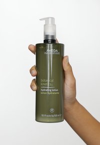 Aveda Botanical Kinetics hydratatie lotion in een duidelijke groene plastic pompflacon, heeft een minimalistisch ontwerp met witte tekst aan de voorkant.