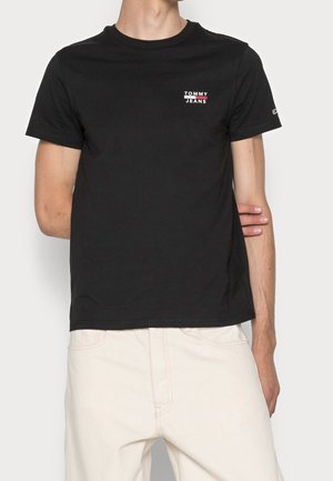 T-shirt en coton noir avec un col rond, des manches courtes et un petit logo "TOMMY JEANS" blanc et rouge sur la poitrine.