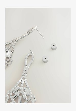 Sudraba piekari ar sarežģītu dizainu, dekorēti ar spīdīgiem rhinestoniem, komplektā ar sudraba aizmugurējām daļām.