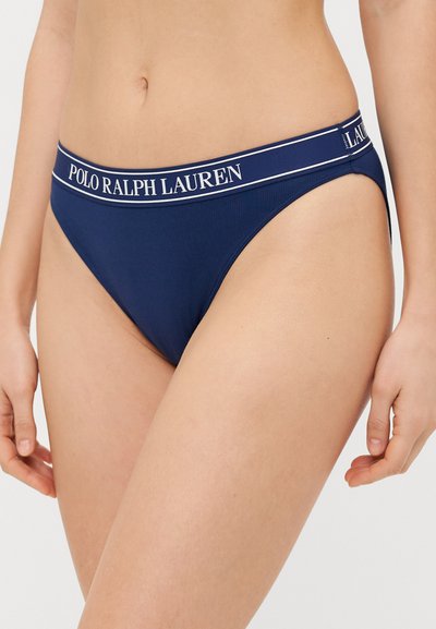 Tamsiai mėlynos spalvos bikini kelnaitės pasižymi griovelių tekstūra, aukšta iškirpte ir elastinga juosta su balta "POLO RALPH LAUREN" ženklinimu.