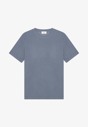 T-shirt semplice a maniche corte con scollo tondo in blu tenue con una piccola etichetta bianca al collo.