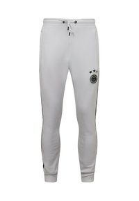 Witte sportieve joggers met zwarte zijstroken, een trekkoord in de taille en een circulair logo met sterren op de linker dij. Gladde stoftextuur.