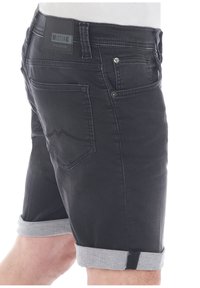 Shorts de mezclilla negra con un dobladillo gris enrollado, que presentan una etiqueta de cuero en la cintura y dos bolsillos traseros con costuras decorativas.