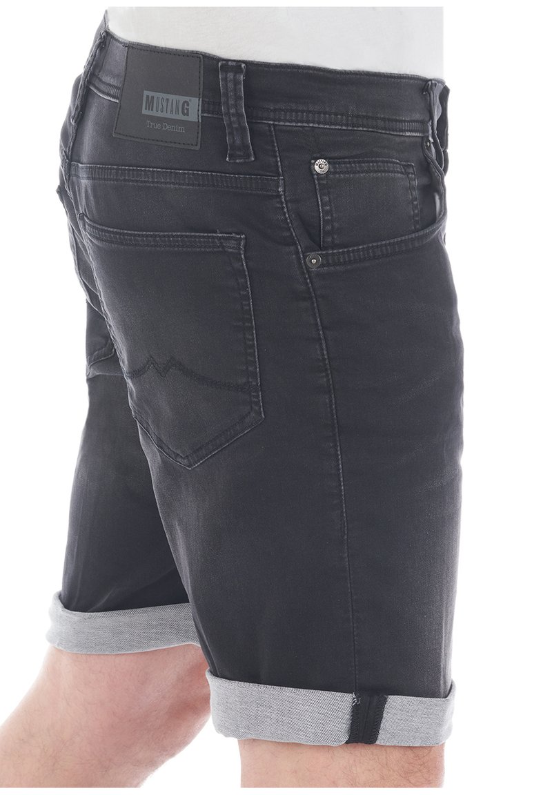 Shorts de mezclilla negra con un dobladillo gris enrollado, que presentan una etiqueta de cuero en la cintura y dos bolsillos traseros con costuras decorativas.
