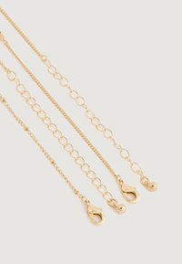 Tres extensores de cadena en tono dorado con cierres de langosta y extremos de bola sobre un fondo claro, mostrando diferentes tamaños y estilos de eslabones.