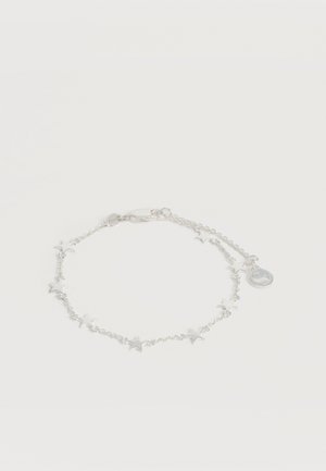 Λεπτό ασημένιο βραχιόλι με μικρά αστέρια-σχήματος κρεμαστά διακοσμητικά και στρογγυλή ετικέτα κοντά στο κούμπωμα τύπου «καβουράκι».